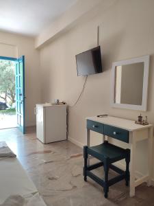 a room with a desk and a television on the wall at Filoxenia Apartments in Rizá