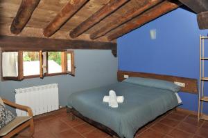 a bedroom with a bed with two white towels on it at LA CABAÑA DE SARA in Vinuesa