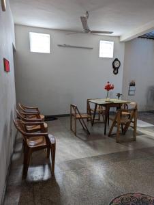 a room with a table and chairs and a clock at Shiranthi Guest House in Rajagiriya