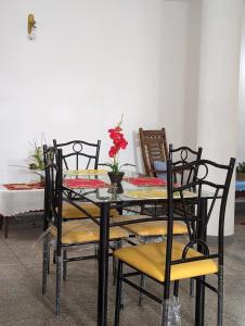 a dining room table and chairs with a table and flowers at Shiranthi Guest House in Rajagiriya