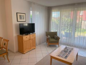 a living room with a flat screen tv and a chair at Apartment Lotte in Zempin