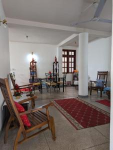 a living room with chairs and a table and chairs at Shiranthi Guest House in Rajagiriya