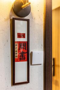 Un espejo en una pared con un cartel. en Tongli 1917 Best South Inn, en Suzhou