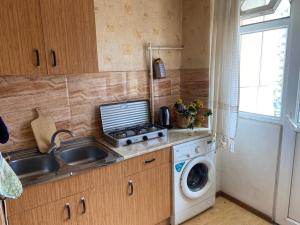 a kitchen with a sink and a washing machine at Квартира студия на улице Цхалтубо in Tbilisi City