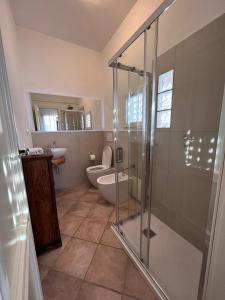 uma casa de banho com uma cabina de duche em vidro e um WC. em Stintino sea front apartments A em Stintino