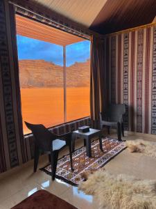 a living room with a large window with a view at Wadi Rum Gulf camp in Aqaba
