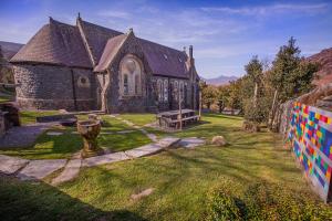 an old church with a bench in front of it at Mountain Church in Capel-Curig