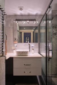 a bathroom with a sink and a large mirror at Taxim home with terrace in Istanbul