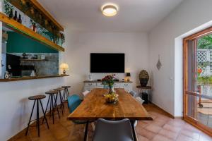 comedor con mesa de madera y TV en Villa Cuore Verde by Perle di Puglia, en San Cataldo