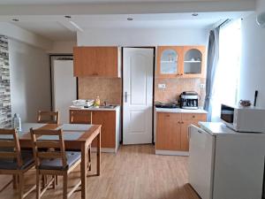 a kitchen with a table and a dining room at Nefelejcs Vendégház in Balatonkenese