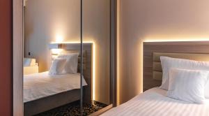 een spiegel in een hotelkamer met 2 bedden bij Antonińska Resort SPA in Boszkowo