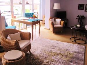 ein Wohnzimmer mit Stühlen, einem Tisch und einem Schreibtisch in der Unterkunft Ferienwohnung am Wanderweg in Aidhausen
