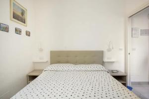 biała sypialnia z łóżkiem z czarno-białą kołdrą w obiekcie A Casa Da Mami w mieście Piano di Sorrento