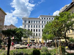 un gran edificio blanco con gente caminando delante de él en Cedar Inn Budapest - Palace District, en Budapest