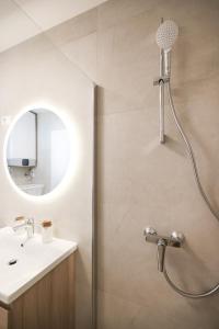 a bathroom with a shower with a sink and a mirror at Apartments Mila in Sveti Filip i Jakov