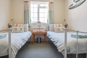 Duas camas individuais num quarto com uma mesa em Harbour Life em Yarmouth