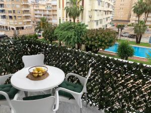 a table and chairs with a bowl of fruit on a balcony at Apartament Bari Playa in Playa de Gandia