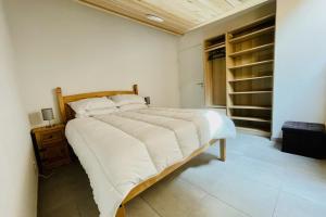 a bedroom with a large bed with white sheets at 100 m near the Cité Vauban in Briançon in Briançon