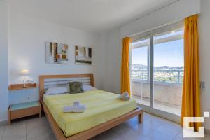 sypialnia z łóżkiem i dużym oknem w obiekcie Apartamento Apolo XVI 67 - Grupo Turis w mieście Calpe