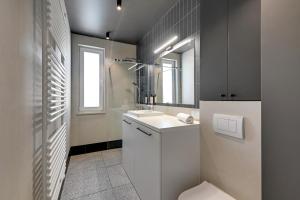 ein Badezimmer mit einem weißen Waschbecken und einem Spiegel in der Unterkunft Luxury Aura 40 - 6 by Grand Apartments in Danzig