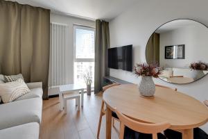 a living room with a table and a mirror at Luxury Aura 40 - 6 by Grand Apartments in Gdańsk