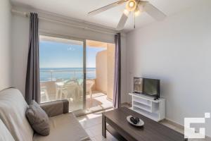 salon z kanapą i telewizorem oraz balkonem w obiekcie Apartamento Apolo XVI 67 - Grupo Turis w mieście Calpe