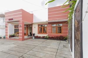 a house with a red and white facade at RedDoorz at WR Supratman Batu in Batu