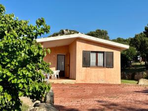 una pequeña casa con un patio de tierra rojo en I bilocali di via Ginestre, Rena Majore, en Rena Majore