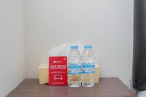 dos botellas de agua están sentadas en una mesa en RedDoorz at WR Supratman Batu, en Batu