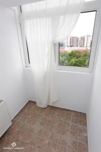 a room with a window with a white curtain at Elegant Concept Studio in Bucharest