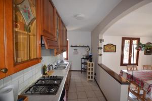 una cucina con lavandino e piano cottura forno superiore di Casa Ginny a Orta San Giulio