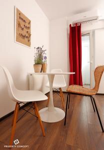 a dining room with a white table and chairs at Elegant Concept Studio in Bucharest