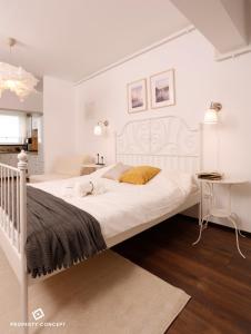 a bedroom with a large white bed and a table at Elegant Concept Studio in Bucharest
