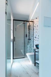 a bathroom with a glass shower and a tub at Hostal Boutique La Mar Serena in Peniscola