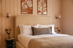 a bed in a bedroom with two pictures on the wall at The Yard in Bath Hotel in Bath