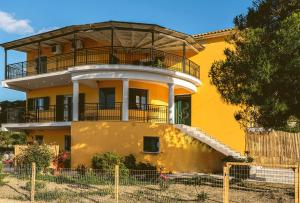 a yellow house with a balcony on top of it at Kotrona Farmhouse - Argassi Zakynthos in Argassi