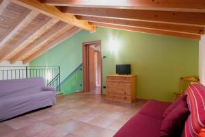 sala de estar con sofá y TV en Agriturismo Il Melograno en Villafranca di Verona