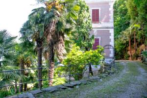 a palm tree and a fence in front of a house at Casa Liberty - WelcHome in Cannobio