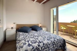 a bedroom with a bed with blue pillows and a balcony at LETS HOLIDAYS Luxury house in Cala Llevado in Tossa de Mar +32 photos
