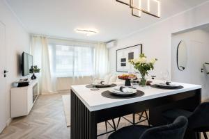 a kitchen and living room with a table and chairs at Mellow - Calea Victoriei - 2BR Luxury Apartment in Bucharest