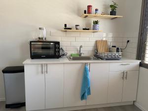 a kitchen with a microwave and a sink at House in Shalma in Tel Aviv