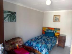 a bedroom with a bed and a chair at Germiston Residential Motel in Germiston