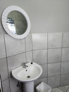 ein Badezimmer mit Waschbecken und Spiegel in der Unterkunft Germiston Residential Motel in Germiston + 34 Fotos