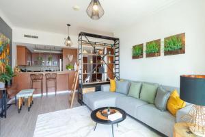 uma sala de estar com um sofá e uma cozinha em Fairways West Tower - 1BR Apartment - Allsopp&Allsopp em Dubai