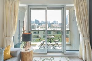 uma sala de estar com uma grande janela com vista para a cidade em Fairways West Tower - 1BR Apartment - Allsopp&Allsopp em Dubai