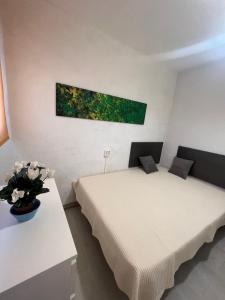 a bedroom with two beds and a vase of flowers at Costa Daurada Apartaments - COLON in Salou