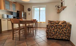 una cucina con tavolo, sedie e divano di TERRAZZA SUL LAGO a Molveno