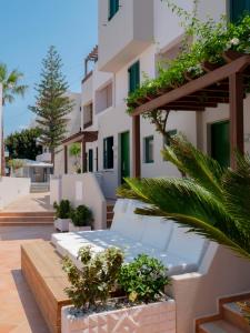 uma vista para um edifício com plantas e árvores em Porto Greco Village Beach Hotel em Hersonissos