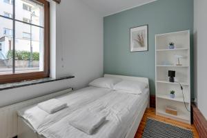 a small bed in a room with a window at Grand Apartments - Balticana Apartment in Sopot