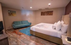 a bedroom with a bed and a blue couch at Empeiria High Sierra Hotel in Mammoth Lakes +64 photos